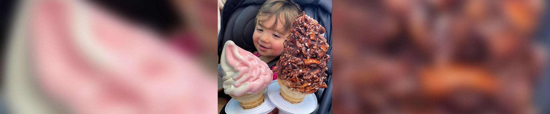 A little girl holding two ice cream cones.