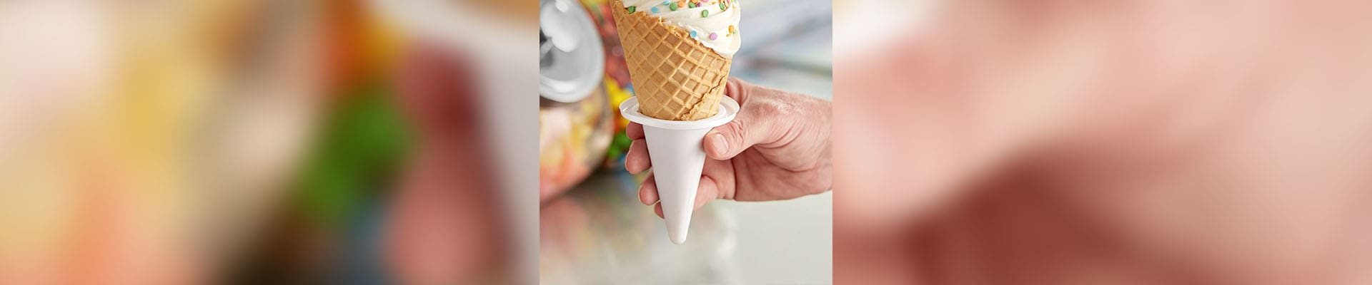 A person holding an ice cream cone in their hand.