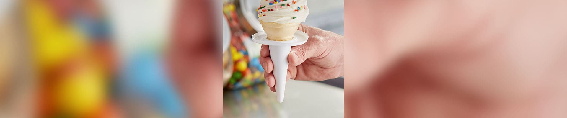 A person holding an ice cream cone in their hand.