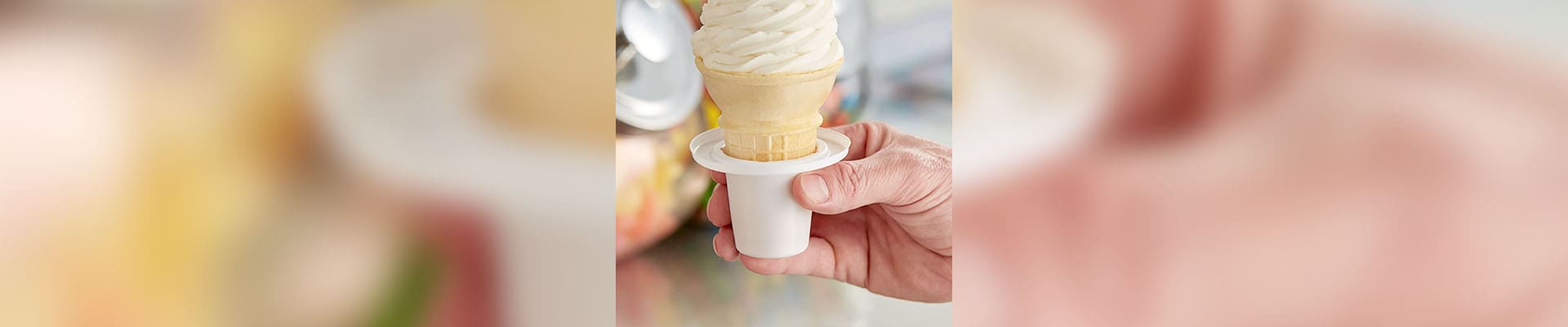 A person holding an ice cream cone in their hand.