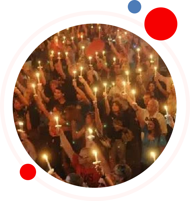 A group of people holding up lit candles.