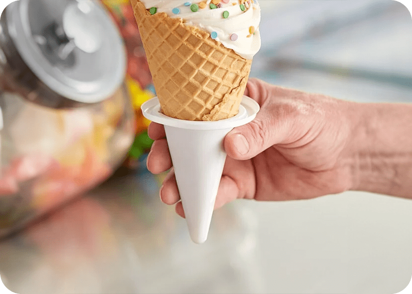 A person holding an ice cream cone in their hand.