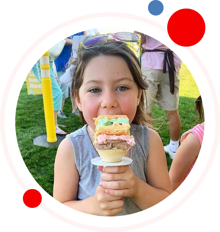 A girl eating ice cream in the park.